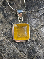 A Natural Yellow Sapphire and Silver Pendant.