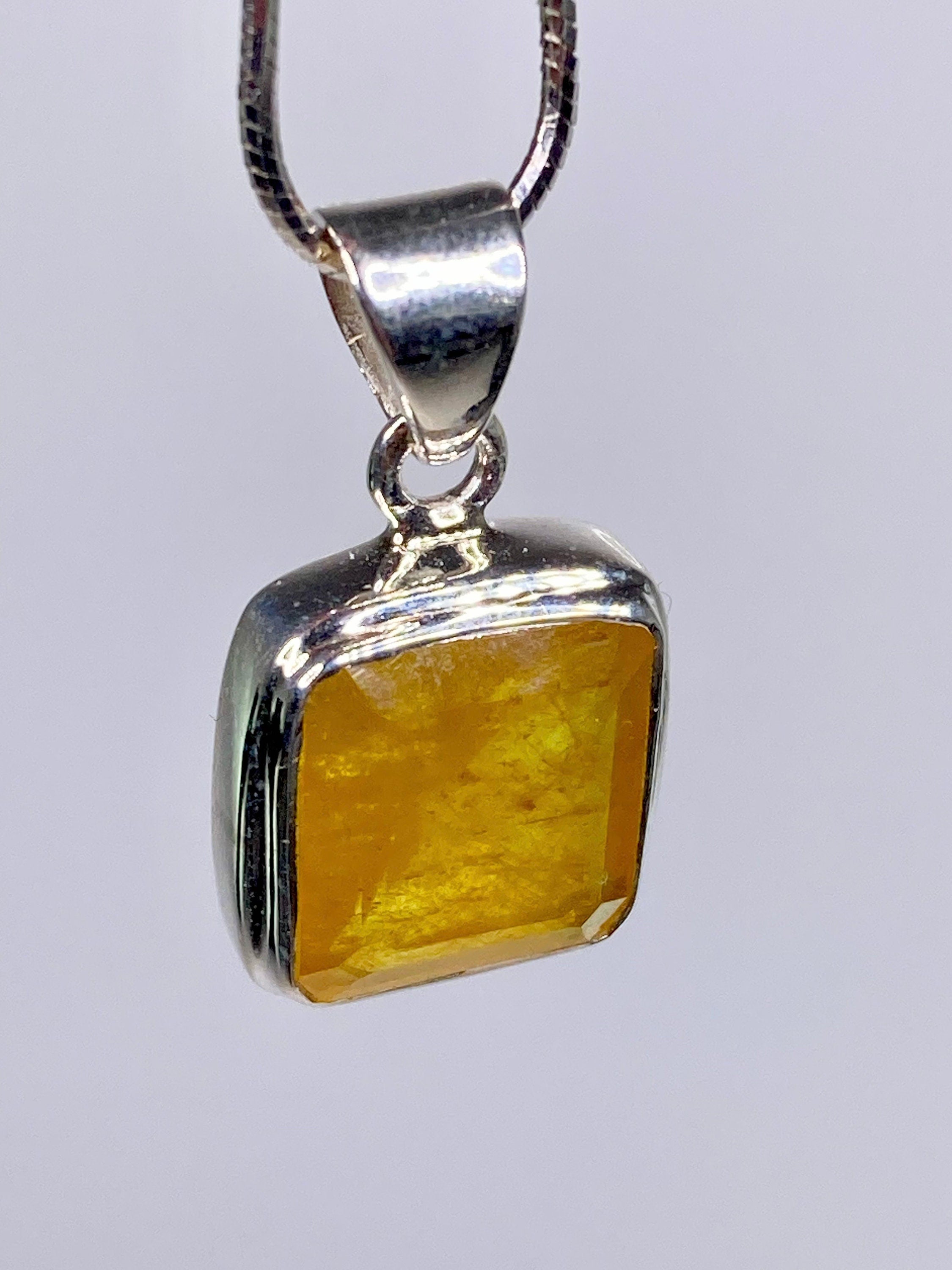 A Natural Yellow Sapphire and Silver Pendant.