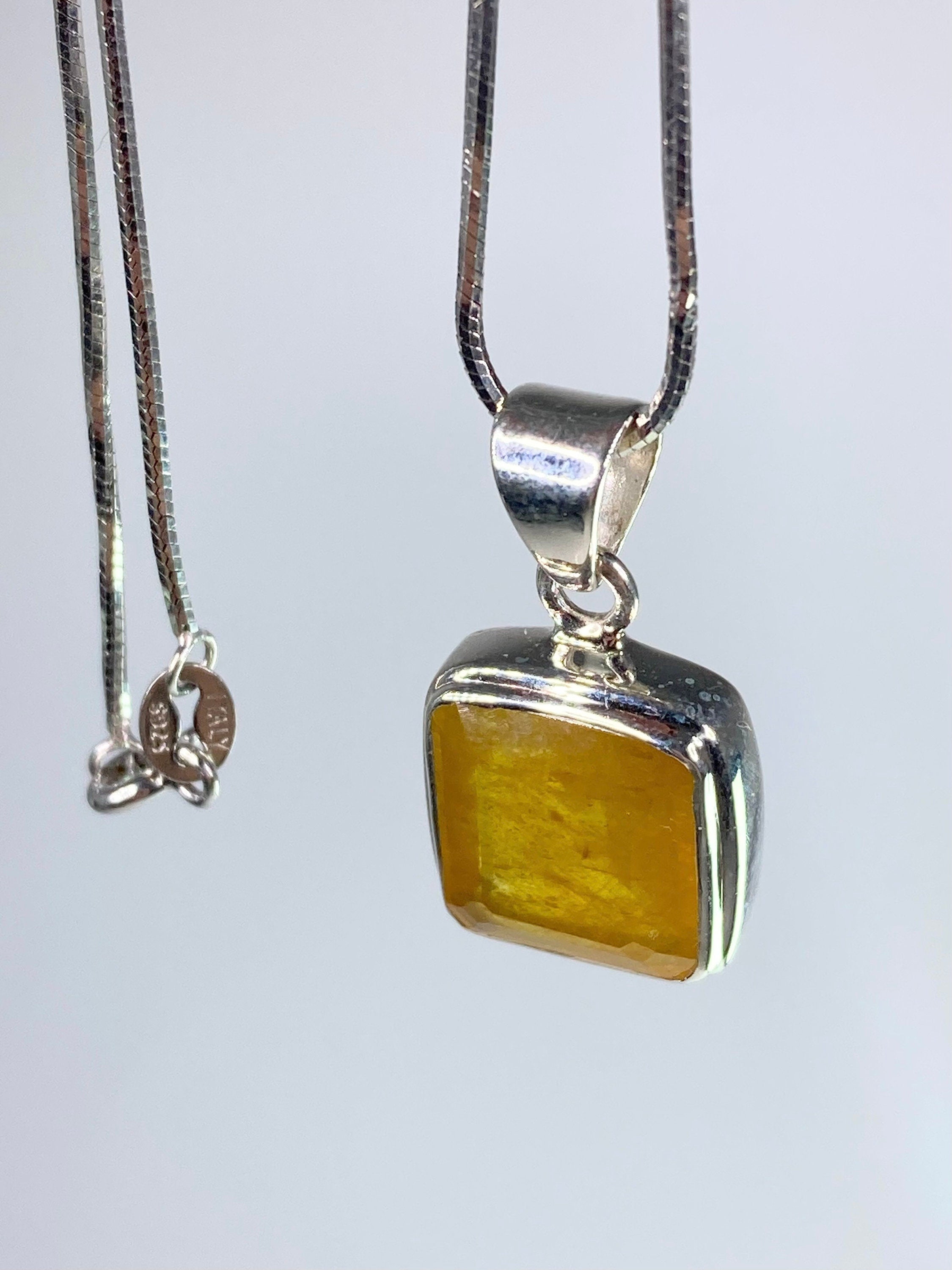 A Natural Yellow Sapphire and Silver Pendant.